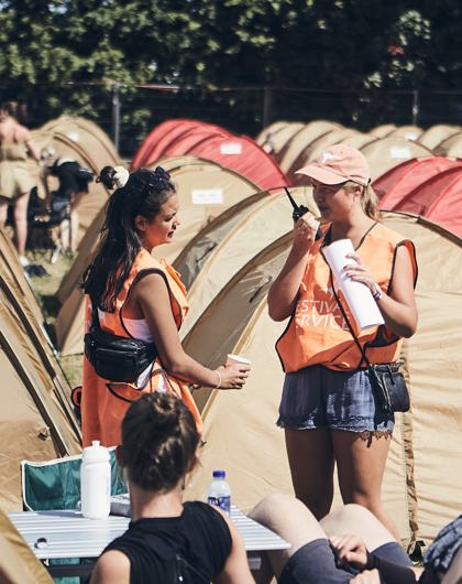 To campingværter der kalder i radio, blandt teltene